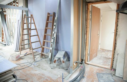Construction site featuring ladders and tools in a home renovation setting.