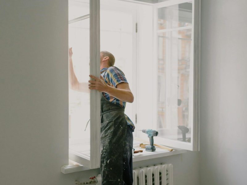 Professional installing a window in a bright modern apartment interior.